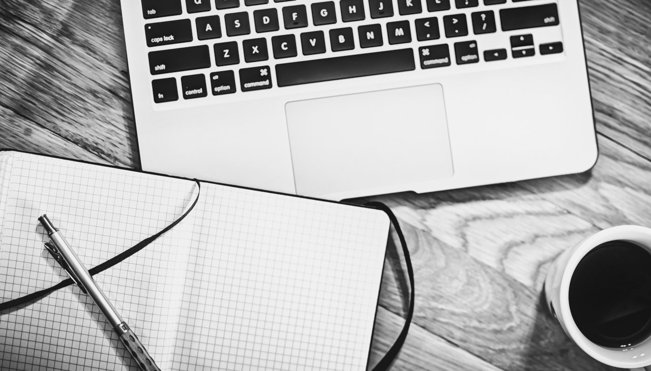 Pc, taccuino e caffè bollente per scrivere un'about page che deve parlare non solo di te....