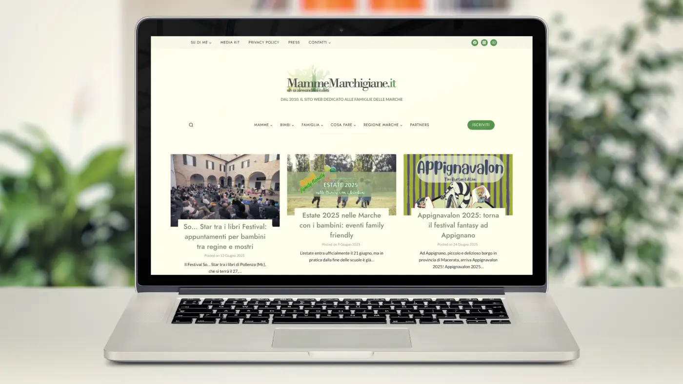 Un laptop aperto che mostra la homepage del sito web "MammeMarchigiane.it", con articoli e immagini in evidenza.